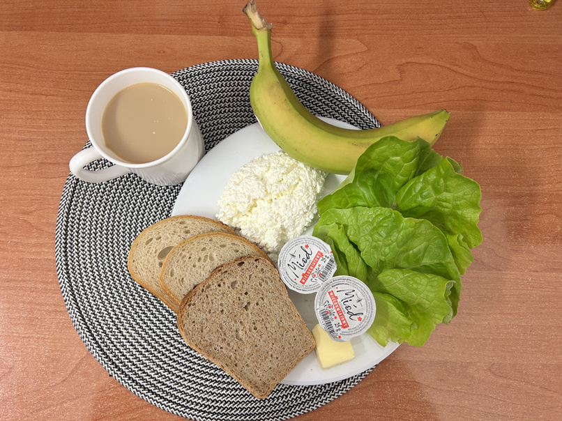 Na zdjęciu: Jogurt naturalny, Kawa zbożowa z mlekiem, Chleb mieszany pszenno-żytni, Chleb Graham, Masło extra 82%, Twarożek, Miód, Banan, Sałata zielona